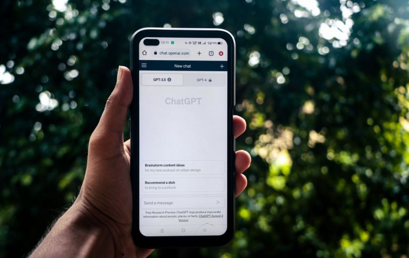 Pessoa avaliando tela com conversa de chatbot e checklists de conformidade