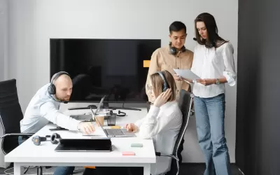Equipe configurando automação conversacional via WhatsApp Business em laptop e smartphone
