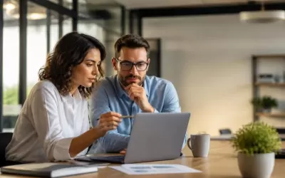 Profissionais revisando conteúdo gerado por inteligência artificial em laptop, focados em sinais de autoridade e SEO