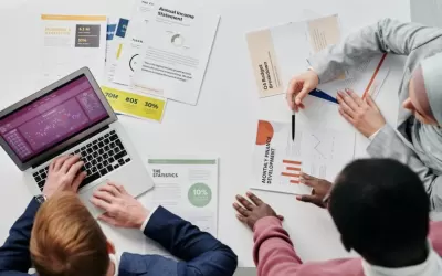 Profissionais do marketing revisando dashboards e relatórios de campanhas online em várias telas