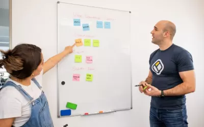 Equipe reunida em escritório revisando conteúdo gerado por IA em telas