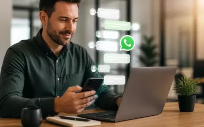 Pessoa usando celular para atendimento via chat ao lado de laptop com gráficos de conversão