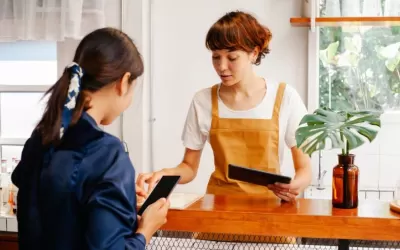 Proprietário de pequena empresa analisando interface de chatbot em smartphone para suporte via WhatsApp